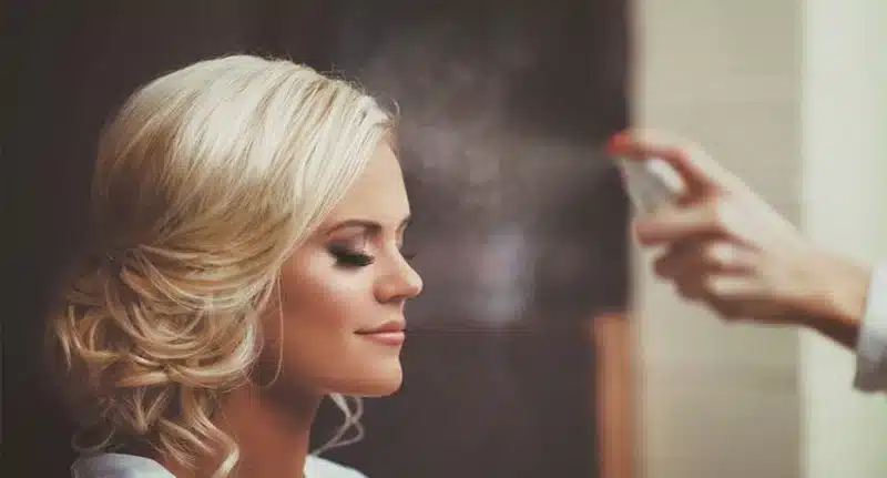 zoomed view of a bride applying makeup spray