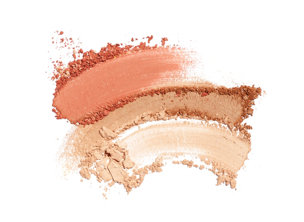 Bronzer or blusher and compact powder brown nude smudge white isolated background