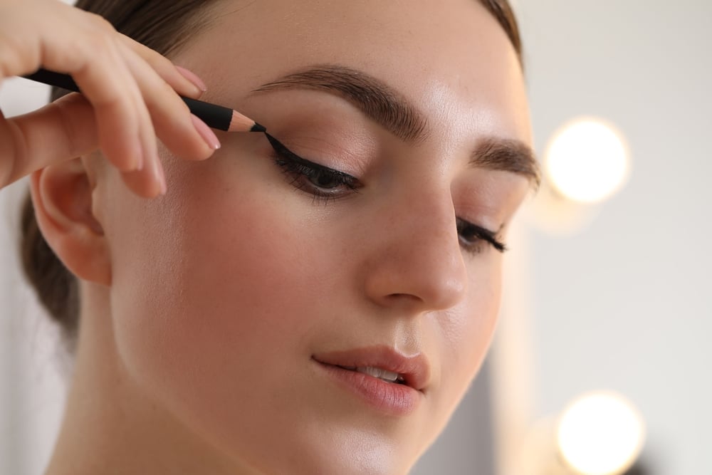 Woman applying black eyeliner