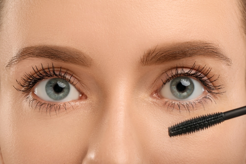 Woman Applying Mascara Onto Eyelashes Closeup View