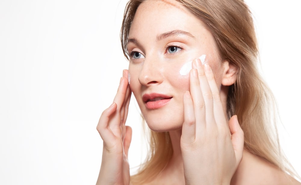 Young Woman Applies Moisturizer To Protect Skin Beauty Portrait