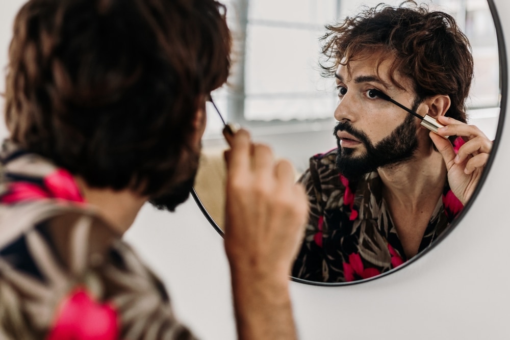 A view of a guy applying mascara