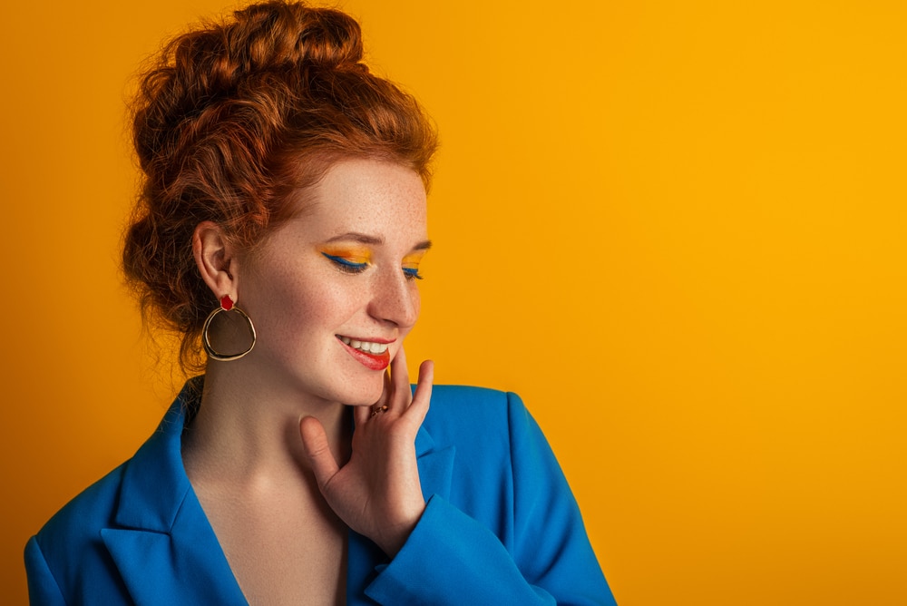 A woman posing sideways wearing yellow summer eyeshadow